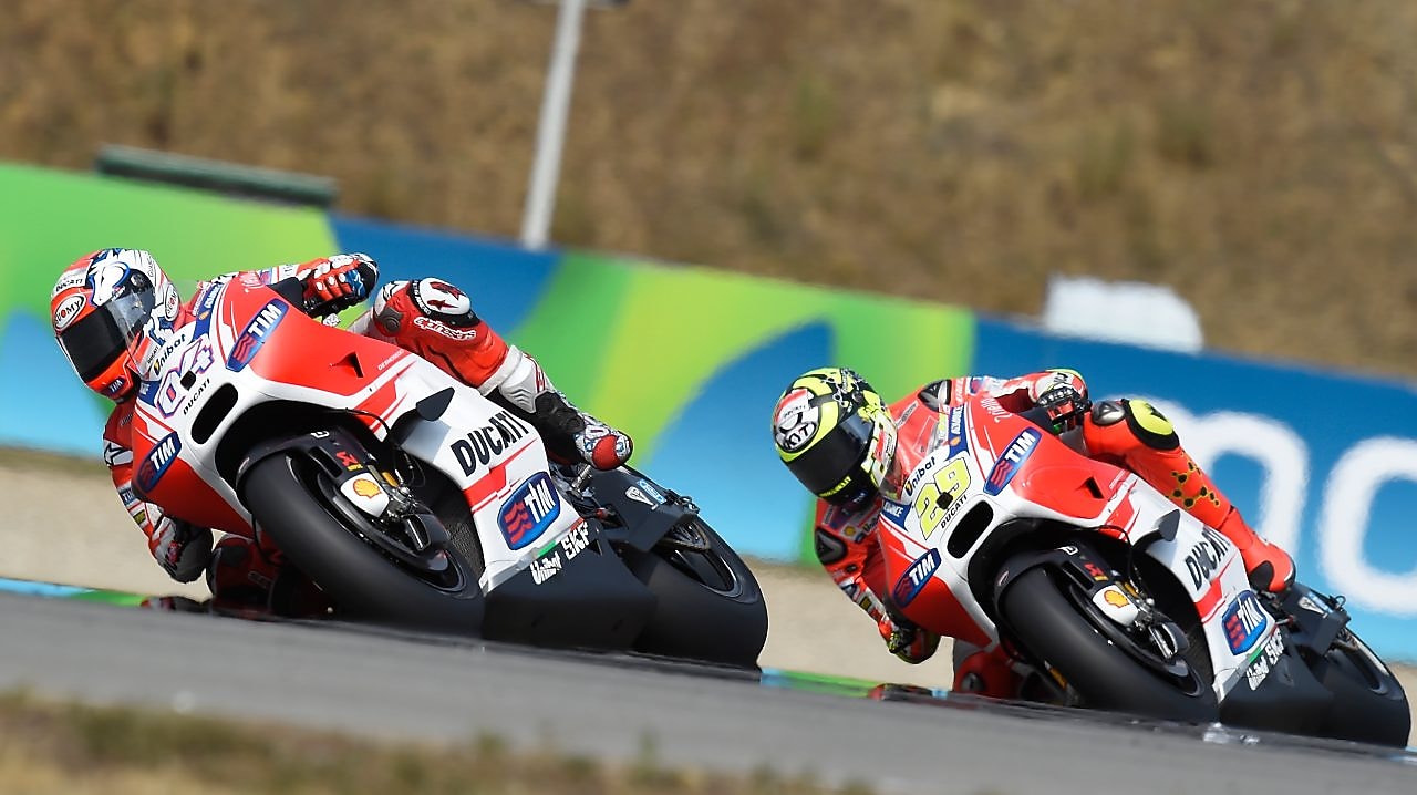 Two Ducati superbikes racing around a track bend