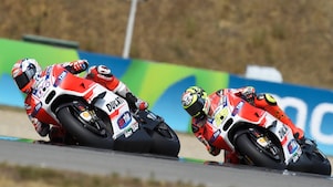 Two Ducati superbikes racing around a track bend