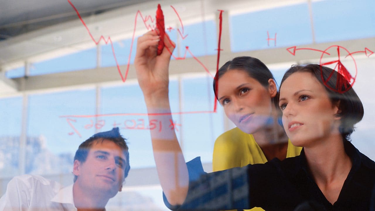 Donna d'affari disegna grafici sul vetro