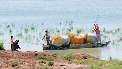 Abitanti del luogo attraversano le paludi allagate di Hawizeh, vicino al progetto Majnoon in Iraq