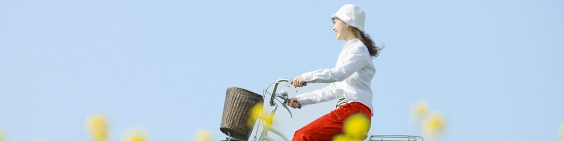 Giovane donna corre in bicicletta nella campagna estiva