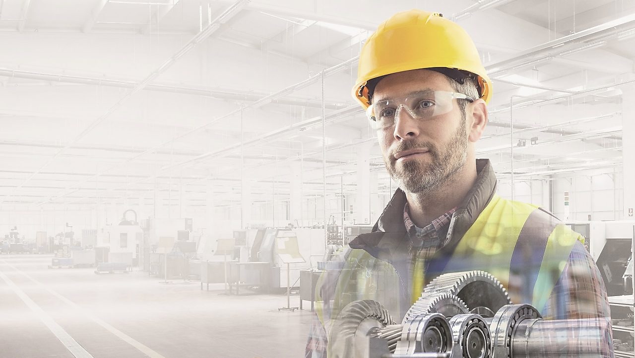 worker in a yellow hard hat transposed onto a background of a power plant