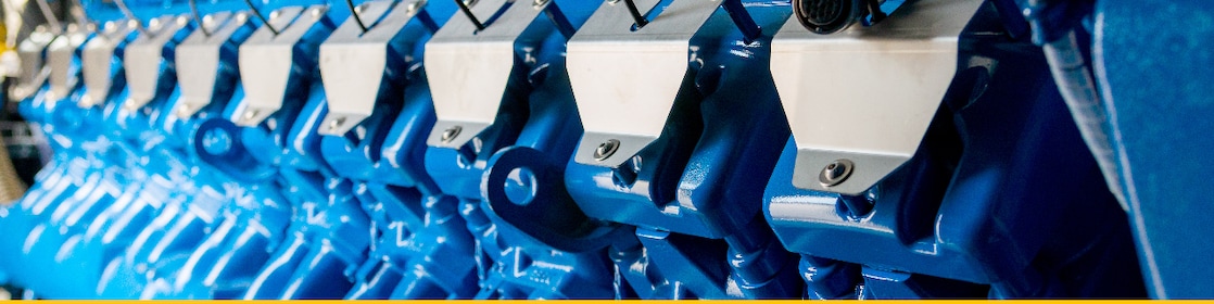 Primo piano di cilindri di motore a gas stazionario blu per la produzione di energia.