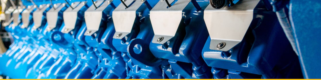 Primo piano di cilindri di motore a gas stazionario blu per la produzione di energia.