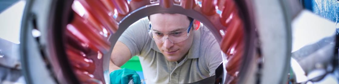 Uomo che versa pellet di plastica in una macchina mescolatrice