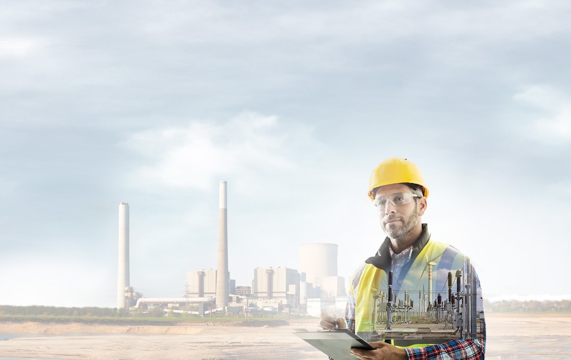 operaio con un casco giallo sovrapposto a uno sfondo di una centrale elettrica