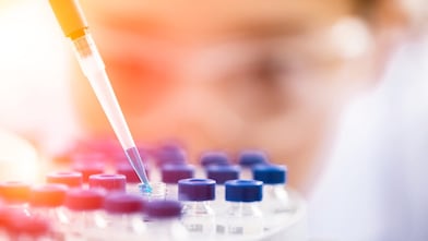 Liquido che viene versato in un imbuto di plastica da uno scienziato shell in un laboratorio