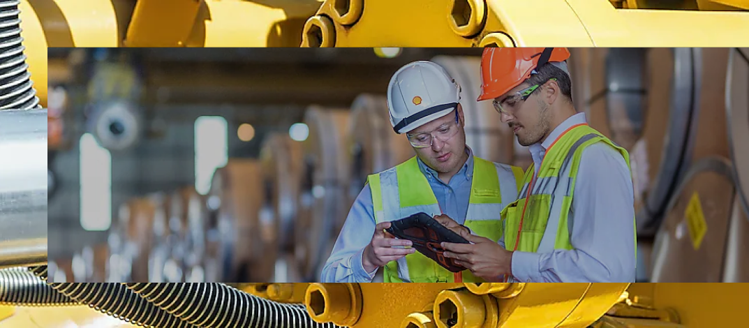 Two Shell employees studying a tablet in factory