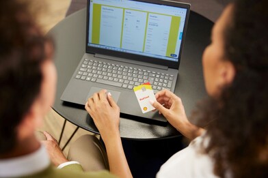 Schermo computer con persone che tengono in mano la carta carburante shell card