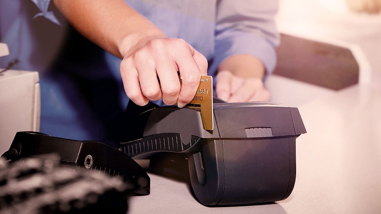 persona che striscia una carta di credito