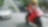 Moto rossa e pilota su una strada con auto ed edifici sullo sfondo