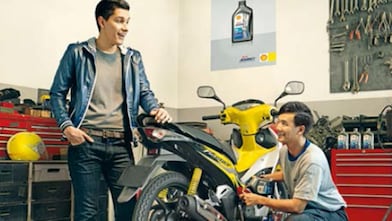 due motociclisti che cambiano l'olio a una moto