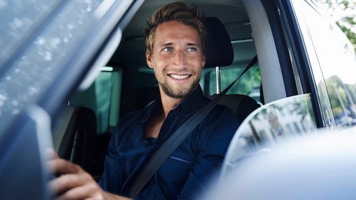 Uomo sorridente seduto al volante di un'autovettura