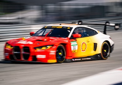 Un'auto da corsa BMW rossa e bianca in pista, come esempio della Partnership tecnologica premium tra Shell Helix Ultra e BMW