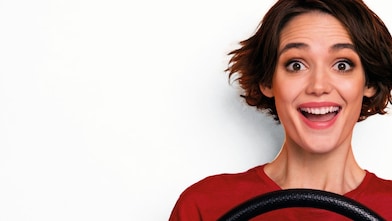 una donna in un'auto che sembra eccitata afferrando un volante