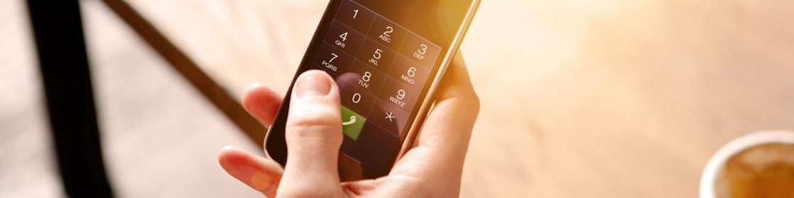 Man holding a mobile phone and drinking coffee