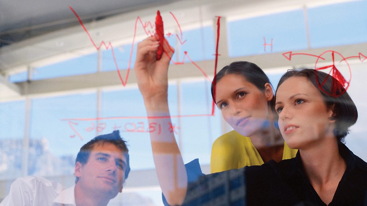 Donna d'affari disegna grafici sul vetro